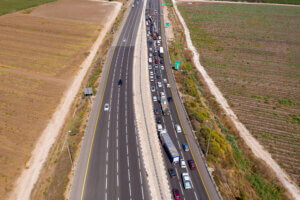 Aerial view of a highway with one lane clear and the opposite lane congested with traffic due to an accident