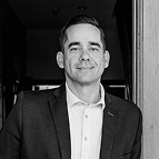 A man in a suit and dress shirt posing for a headshot.