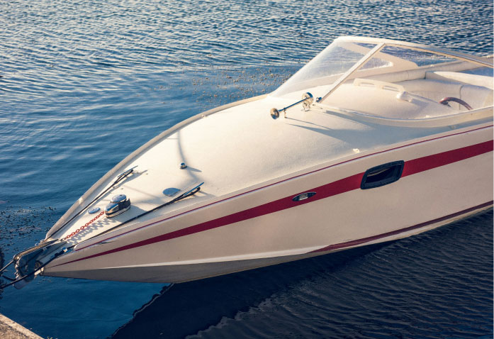 A white speedboat with a red stripe docked on calm water, a scene often associated with personal injury claims.
