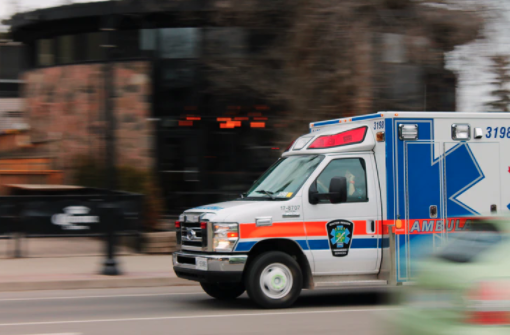 An ambulance driving down a street with motion blur.