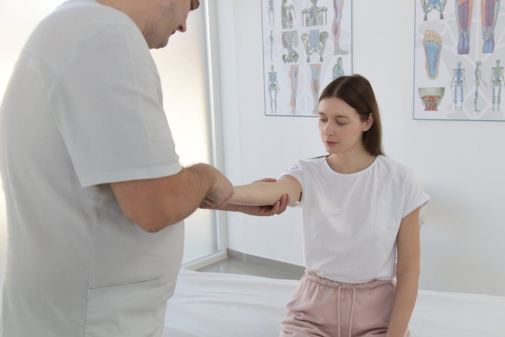 A woman at a checkup appointment for the dog bite on her arm with a doctor