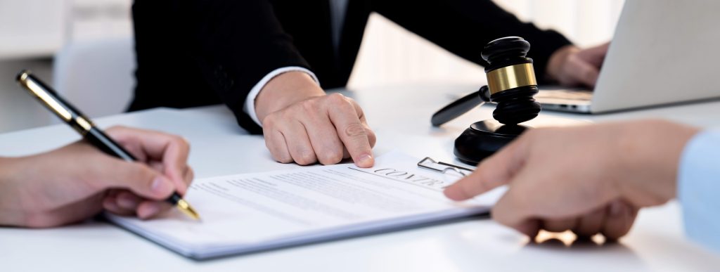 three people looking at a contract and signing it