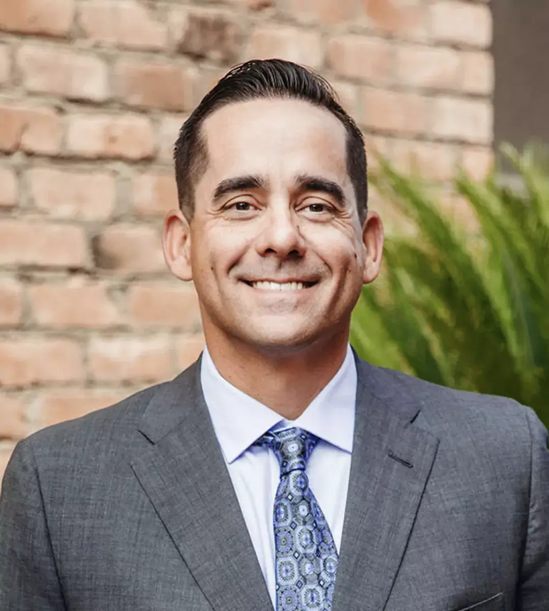 John Torgenson in a suit and patterned tie smiling at the camera.