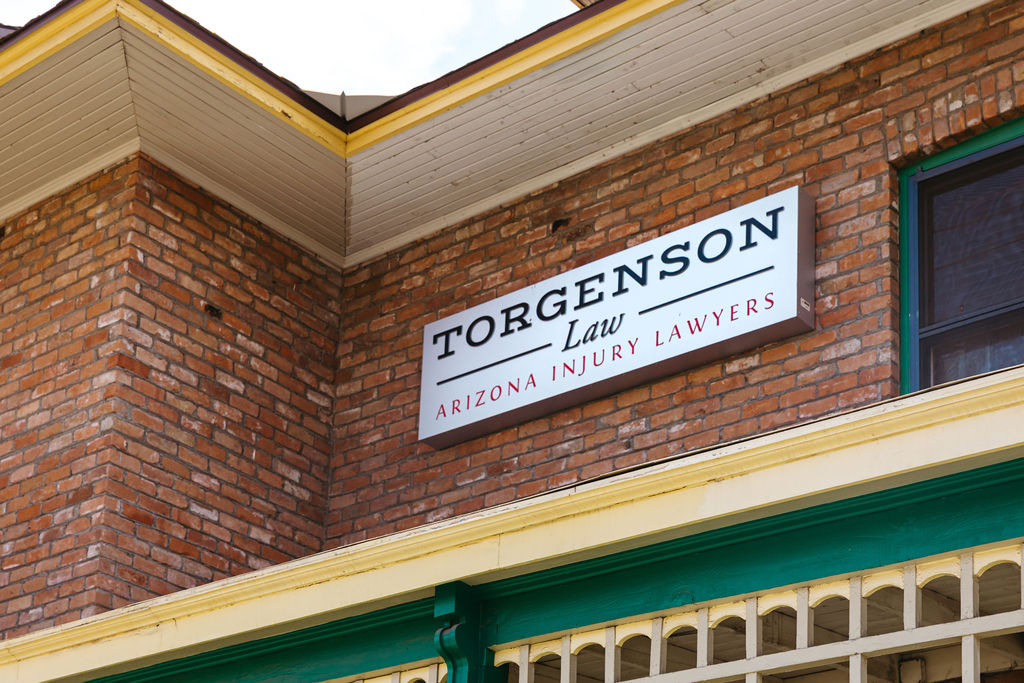 Sign for Torgenson Law, Arizona construction accident and injury lawyers, mounted on a brick building.