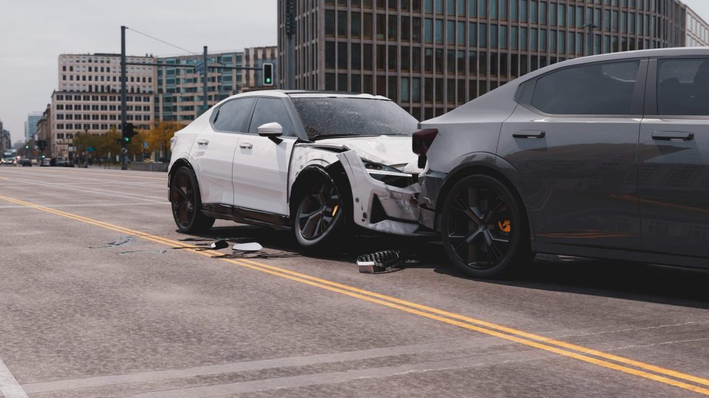 A white waymo and a dark gray car are involved in a rear-end collision